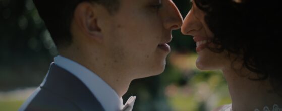Close-up of Noémi and Juan Martin facing each other in the garden of Tópart Hotel in Balatonvilágos during their wedding day – detail from their wedding film. Balaton wedding videographer