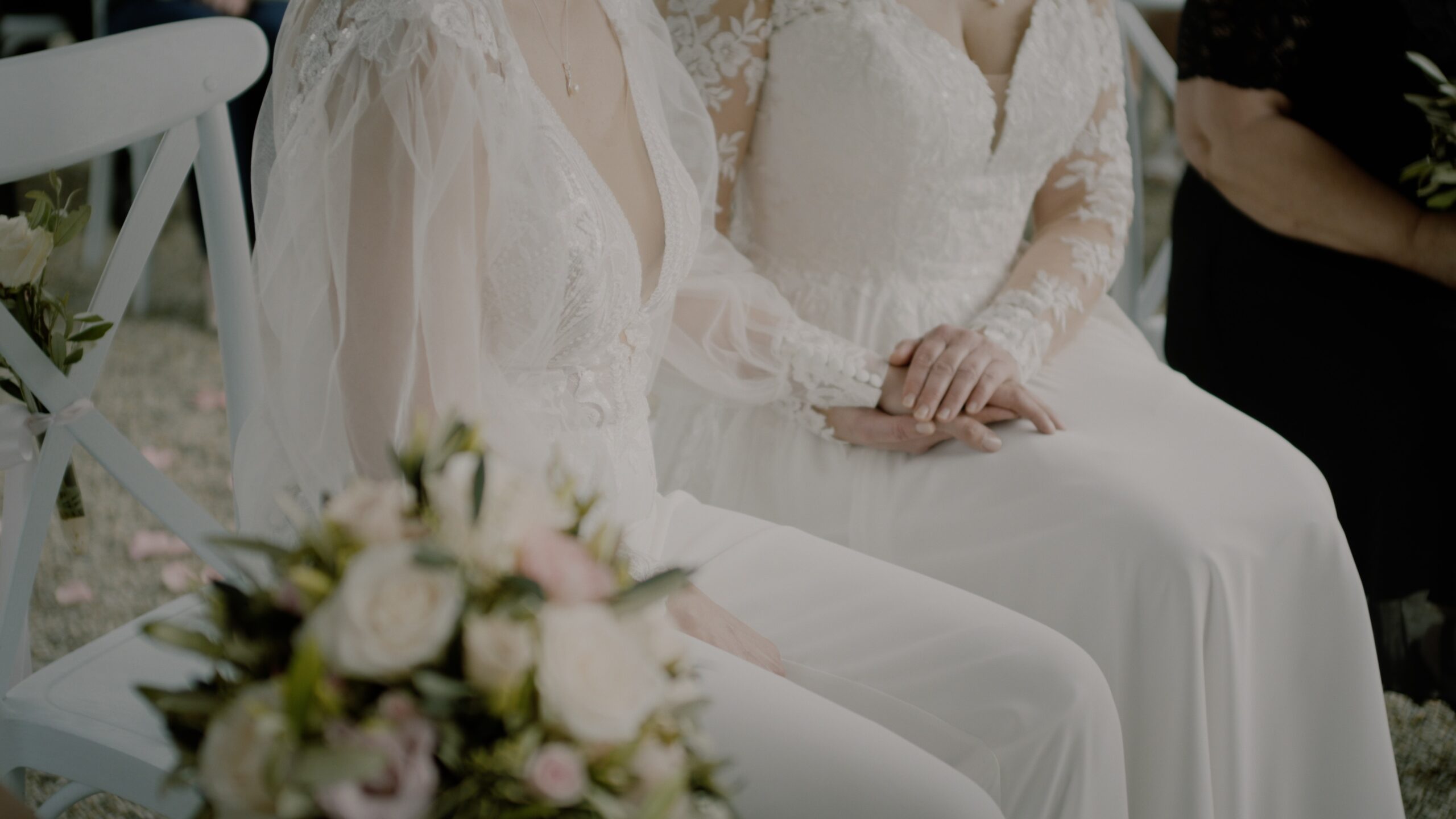 Cornelia und Venere umarmen sich im Park von Schloss Obermayerhofen während ihrer LGBTQ‑Hochzeit in Österreich.
