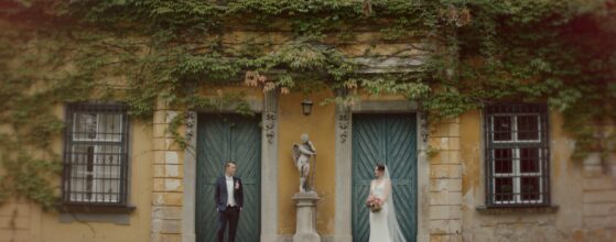 Elena und Maximilian vor der bewachsenen Fassade von Schloss Marchegg in Niederösterreich, Hochzeitsfilm‑Porträt mit natürlicher, romantischer Stimmung. Niederösterreich hochzeit videograf.