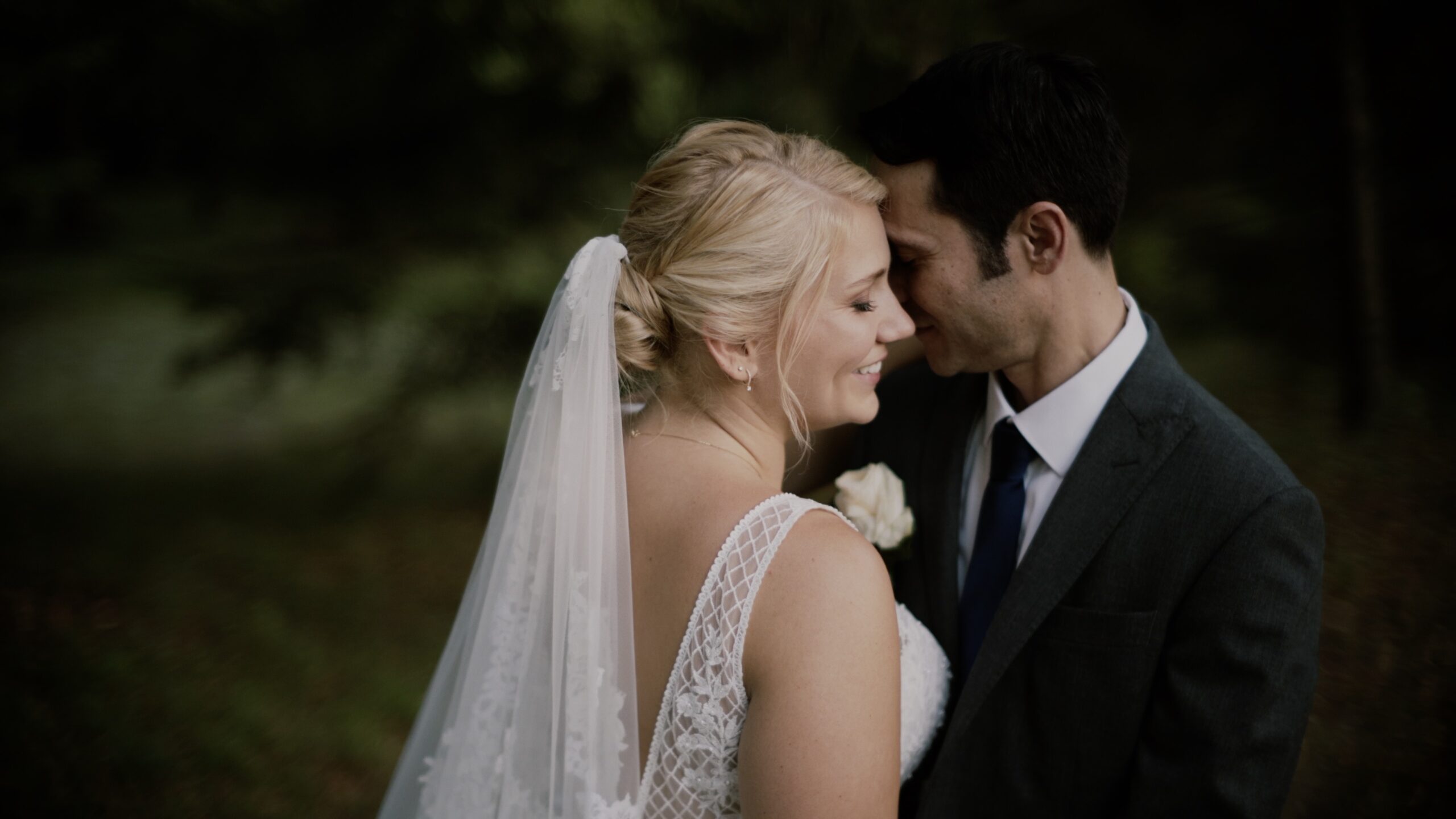 Katharina und Luis stehen auf dem Weg im Schloss Miller von Aichholz in Wien in elegantem Brautkleid und klassischem Smoking.