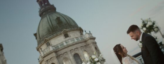 Viktória és Attila esküvői csókja az Aria Hotel Budapest tetőteraszán, háttérben a Szent István-bazilikával, naplementés esküvői film jelenet.